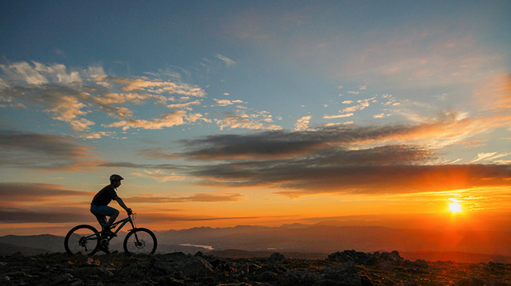 Silhouette of a cyclist against a sunset