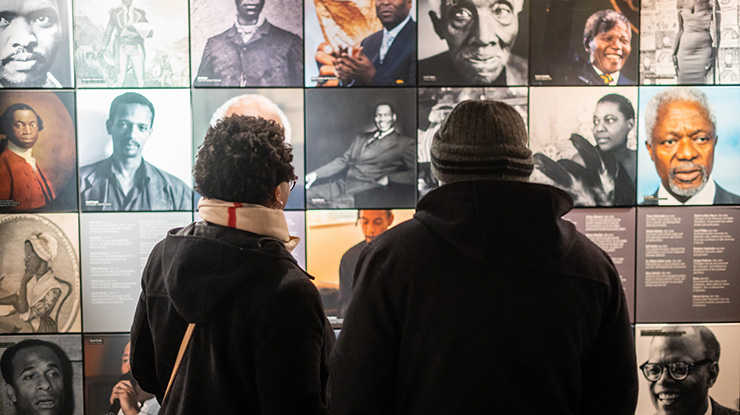 Two people looking at a display of images at the International Slavery Museum
