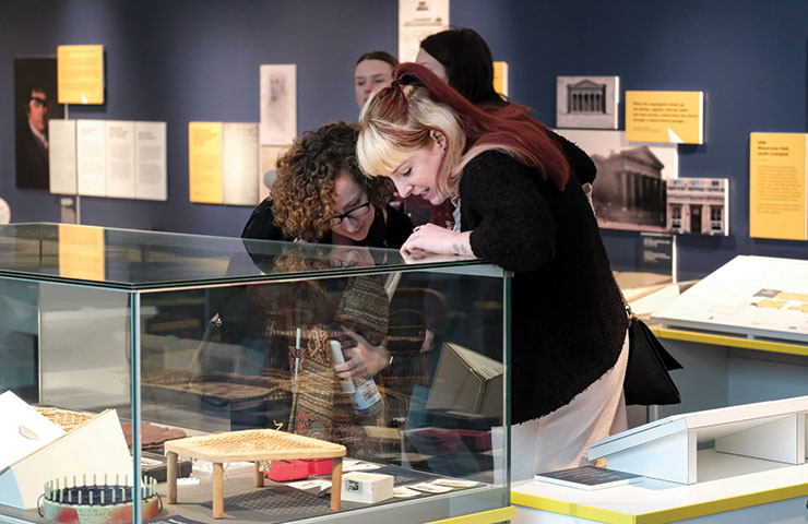 Two people looking at a glass display cabinet at a museum exhibition