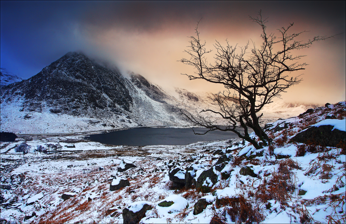 A mountain and lake scenery of Llyn Ogwen in Wales, covered in snow