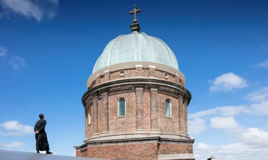 A person stands on the roof of the Church of Saints Peter and Paul and Saint Philomena and inspects the newly conserved dome