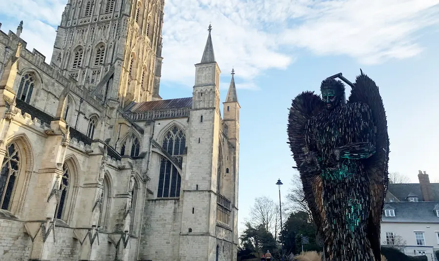 A sculpture of an angel made up of over 100,000 knives is on display and Gloucester Cathedral can be seen next to it
