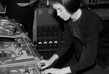 A black and white photograph of Delia creating electronic music.