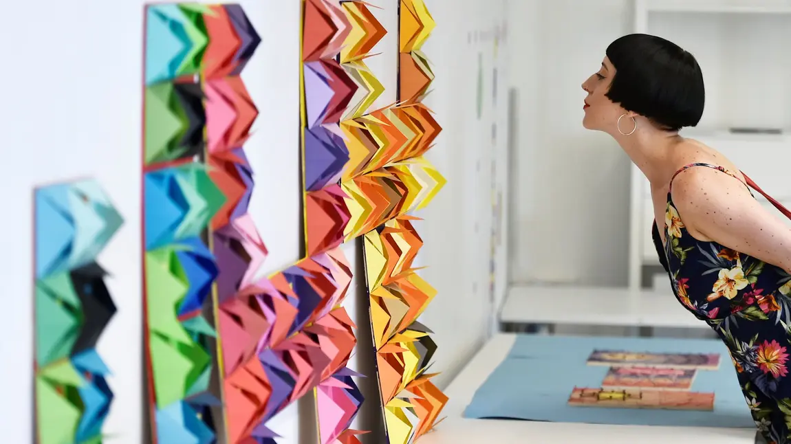 A woman looks at a colourful exhibit 
