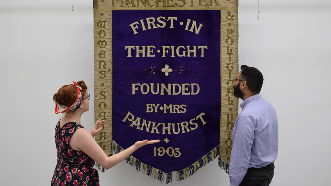 Helen Antrobus & Adam Jaffer from the People's History Museum with the Manchester suffragette banner