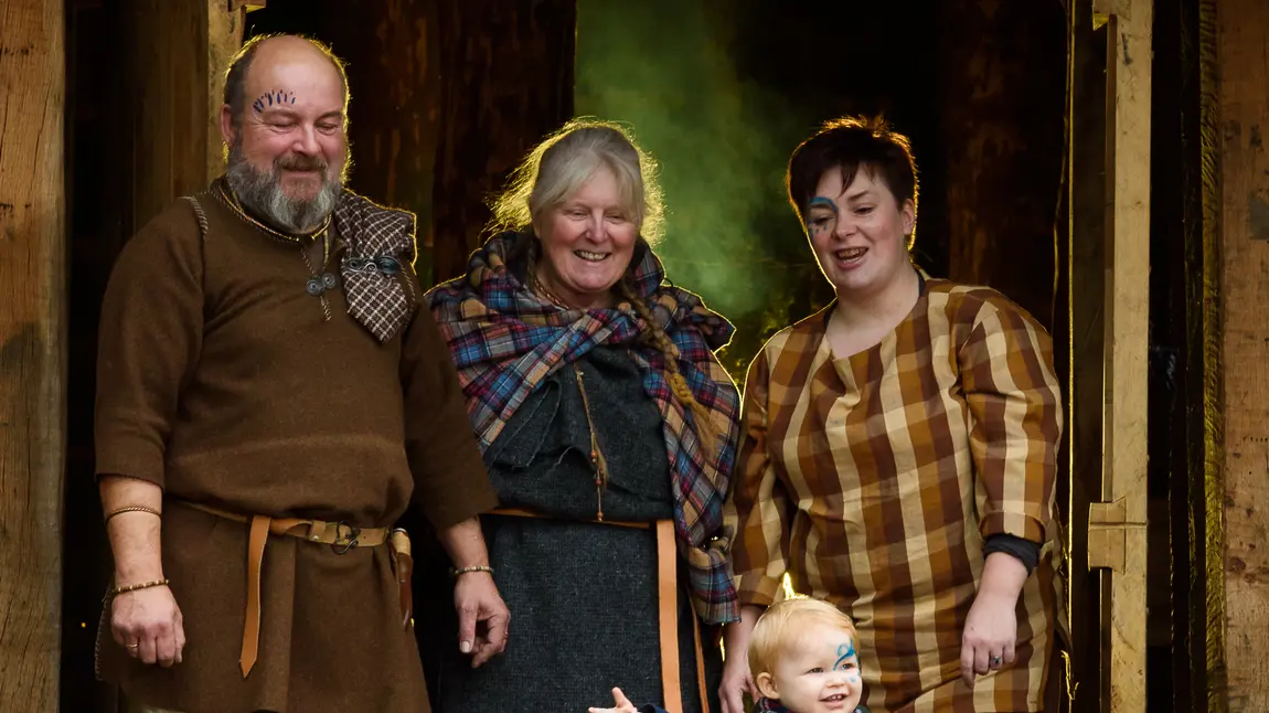 A family group in Iron Age dress in the doorway of the round House